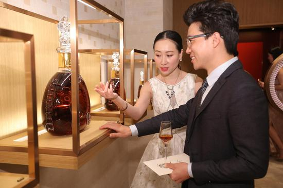 路易十三品牌传讯经理史佳琼（左）向央视主持人李子超（右）介绍路易十三 LE MATHUSALEM六公升装，在路易十三之家 “启示厅”内感受路易十三的非凡魅力