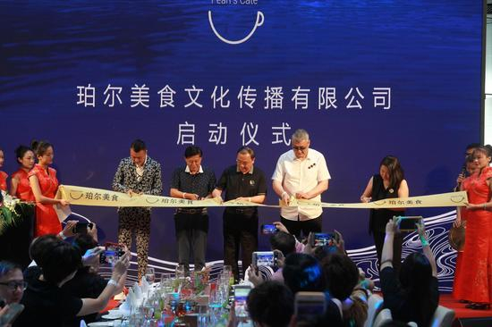 世界中餐业联合会常务副会长邢颖，世界中餐业联合会国际中餐名厨专业委员会主席、大董中国意境菜创始人、北京烤鸭代言人董振祥先生，前海淀区饮食服务行业协会会长胡滨先生、安赐资产管理有限公司业务合伙人刘美辰女士，以及珀尔美食文化传播有限公司合伙人司明先生，共同为“珀尔美食”剪彩揭幕