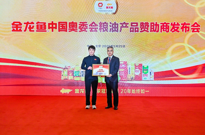 益海嘉里金龙鱼食品集团股份有限公司品管总监潘坤（右一）授予北京2022年冬奥会自由式滑雪空中技巧冠军齐广璞（左一）金龙鱼“品质监督官”身份