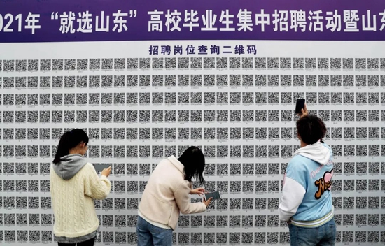 　　2021年3月20日，山东科技大学春季校园双选会在青岛西海岸新区举行，吸引了7000余名大学生前来求职。大学生通过扫码了解招聘岗位信息。