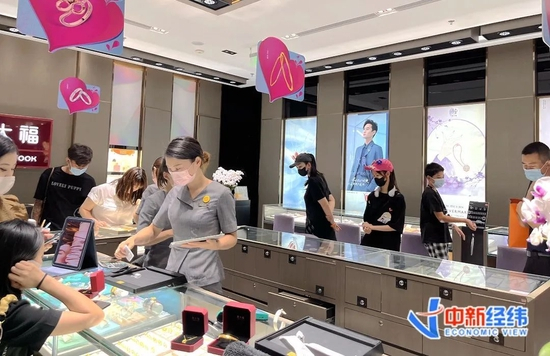▲8月22日晚，在北京某商场内，不少消费者选购黄金饰品。中新经纬闫淑鑫摄