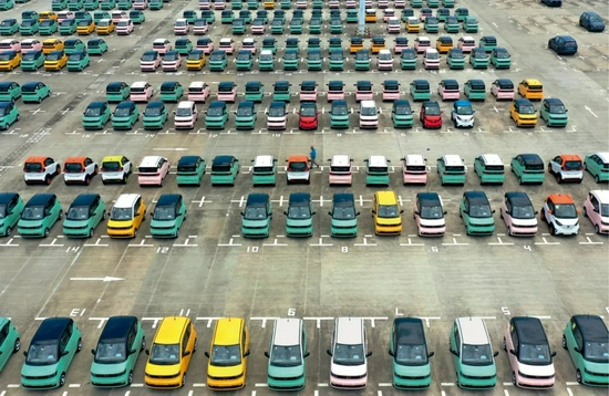 ▲8月12日，广西柳州一家汽车物流园，工作人员检查准备外运的新能源汽车。黎寒池摄/本刊