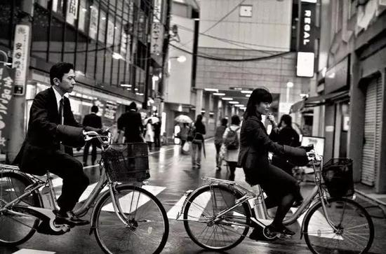 （日本街头，骑单车上下班的工薪阶层。 图/视觉中国）