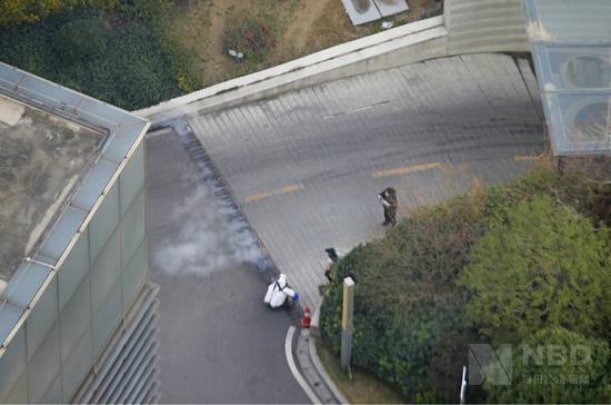 武汉一位身着防护服的人员在进行室外消毒&nbsp; 图片来源：每经记者 张建