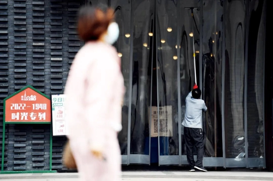 5月11日，工作人员在郑州市一家商场门口打扫卫生。图/新华