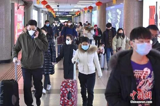 　1月30日，北京西站，旅客佩戴口罩出站。　中新社记者 张兴龙　摄