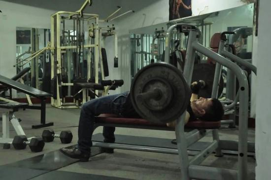 49 岁的王旭阳算得上健身房里的年轻人，下班后匆忙赶来卧推几把。中青报·中青网记者 马宇平/摄