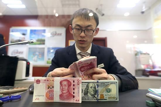 银行工作人员正在清点货币。 视觉中国 资料图