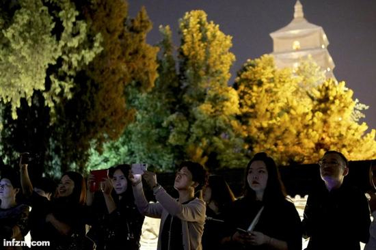 　西安大雁塔北广场。用手机拍摄音乐喷泉表演的市民。在西安，利用“抖音”等新媒体工具，被主政者视为推广城市的重要方法。（南方周末记者 冯飞/图）