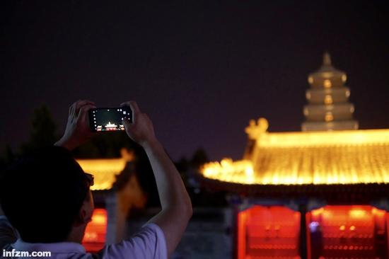 　一名男子举起手机，拍摄大雁塔。（南方周末记者 冯飞/图）