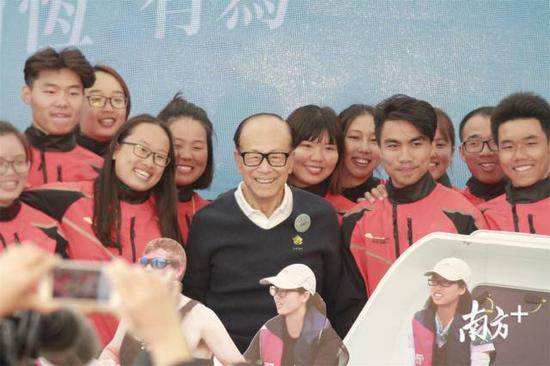 2017年2月19日12时，89岁的李嘉诚站在香港黄埔海滨长廊私人码头上，迎接20名从汕头启程的汕头大学划艇队学生，他们历时8天划艇640公里，终于在香港顺利登岸。图为李嘉诚在迎接仪式上与20名汕头大学划艇队学生合影。南方日报记者万稳龙 摄。