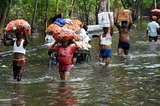  　10月4日，在印度比哈尔邦首府巴特那，人们搬运救灾物资。新华社发