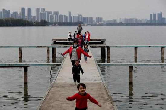3月28日，一家人在武汉东湖边散步。武汉将于4月8日迎来“解封”，市民正在有序回复日常秩序。摄影/中国日报 王敬&nbsp;