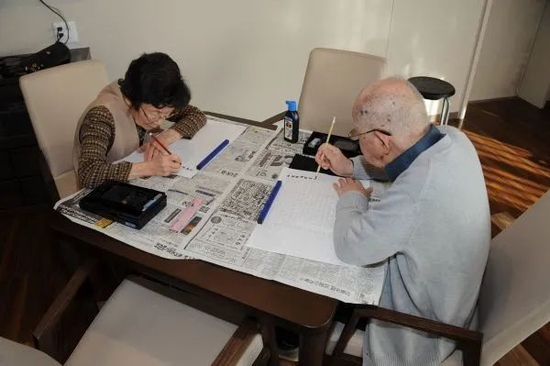 ▲在位于日本东京品川区的养老院“日医HOME南品川”，两名老人在练习描字。新华社记者 华义 摄