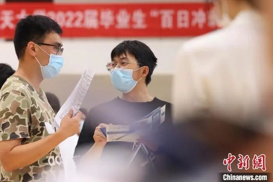 资料图：招聘会上大学生相互交流。泱波 摄