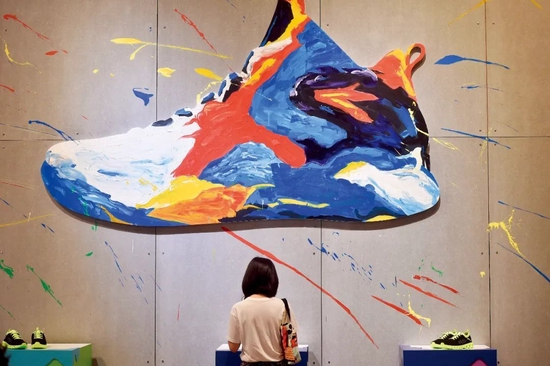 　　2017年4月18日，在中国（晋江）国际鞋业暨国际体育产业博览会上，一位客商在了解安踏运动鞋。图/新华