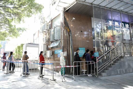 12月10日14：30，越秀区的广州医科大学附属第二医院的发热门诊约有20人在排队，间隔1米以上，井然有序（陈月芹/摄）