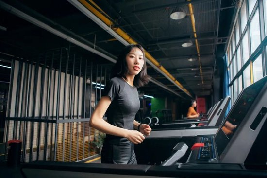 年轻女孩在健身房使用跑步机进行运动健身、塑造身材。（图/图虫创意）