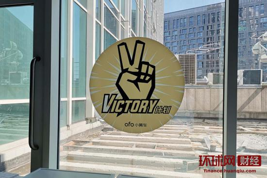 ofo小黄车总部内窗户上的贴纸，上面写着“Victory”计划。 环球网记者 邓云 摄