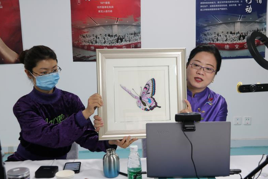  夏华展示独臂绣娘梁老师的精美蝴蝶绣片