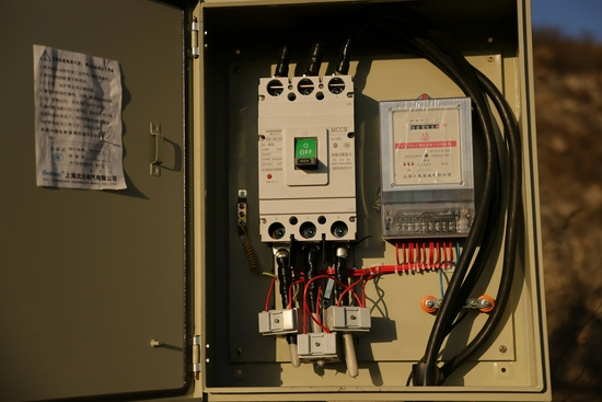 ▲黑煤窑供电的变压器配电箱盒，事发后电缆已被切断。新京报记者 李英强 摄