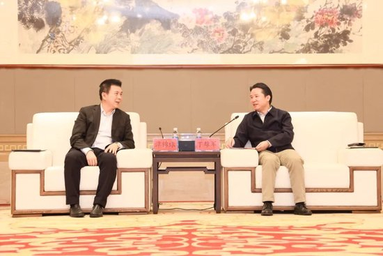 谭锦球（左）与丁雄军（右）交流