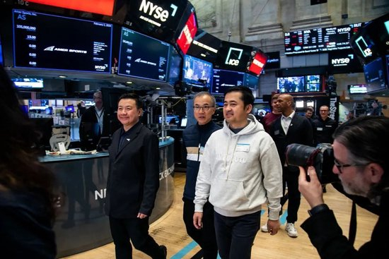 始祖鸟母公司亚玛芬体育上市仪式，丁世忠身着灰色卫衣出现在纽交所现场。图片来源：视觉中国