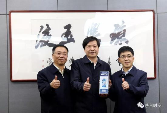 雷军分别与茅台集团党委书记、董事长李保芳和茅台集团党委副书记、总经理李静仁交换礼物