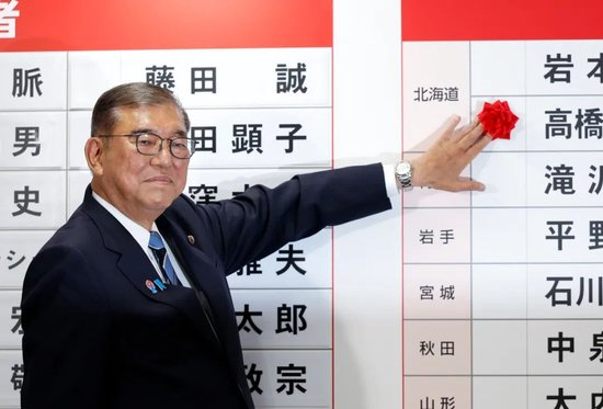  7月20日，在日本东京自民党总部，石破茂为当选议员贴花。新华社发（Pool图片，弗兰克·罗比雄摄）