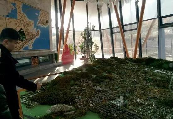 万科青岛小镇销售顾问在介绍沙盘