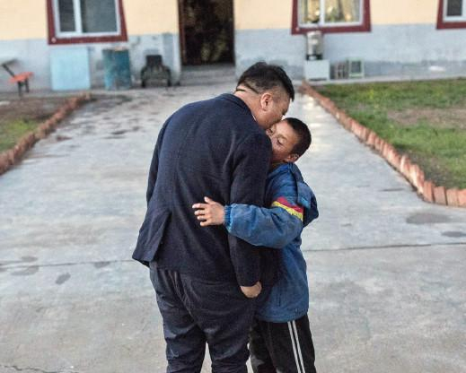 　2018年8月9日，青海玉树曲麻莱县麻秀村小，校长嘎松扎西回到学校，孩子们看见了，跑过来和他贴贴面。这已经是麻秀学生和老师的习惯了。（刘关关 / 摄）