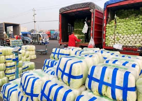 　　▲ 北京新发地市场，货车司机们正在卸货。