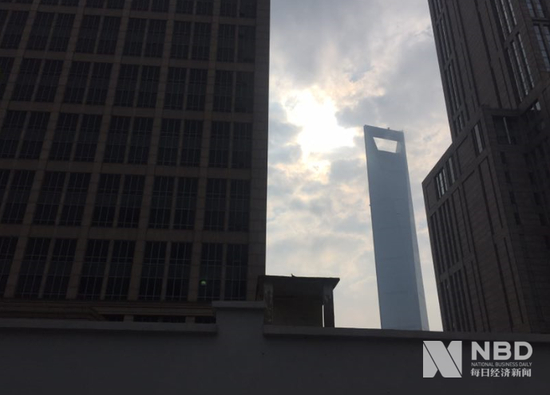 通过黄金置大厦间隙可望见不远处的上海环球金融中心