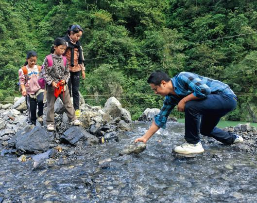 2016年5月11日，云南怒江贡山县捧当乡，捧当完小老师桑磊护送学生回家。（沈伯韩 / 摄）