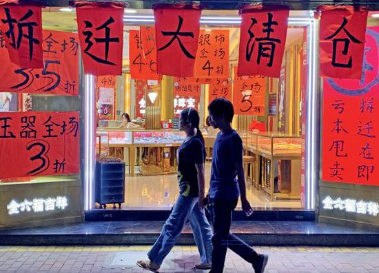 白石洲的很多商家打出了拆迁甩 货的招牌，随着住户大量搬离， 店里的生意也日渐冷清。 摄影/ 本刊记者 程昕明