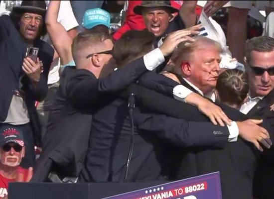 　　这张视频截图显示，7月13日，美国前总统特朗普在宾夕法尼亚州巴特勒市的竞选集会现场被护送离开。新华社发不足与建议