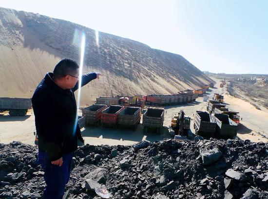 　　3月16日，神木考考赖沟综治项目负责人喻建林手指的方向，是滞留在工地上的五六十台渣土运输车、挖机等作业机器。摄影/本刊记者 周群峰