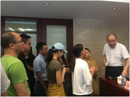 图为王广西（右一）向媒体介绍情况，野马财经拍摄