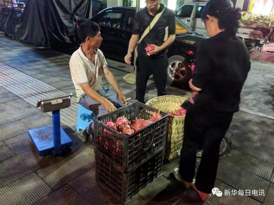火龙果种植户在关岭县城摆摊出售火龙果。本报记者张典标摄