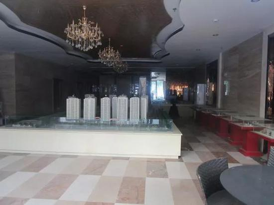 透过越州国际广场营销部内沙盘及其设施台面地面