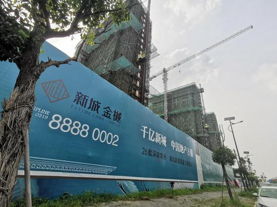 7月6日，新城金樾项目外的围墙上，“千亿新城 中国地产8强”的广告。