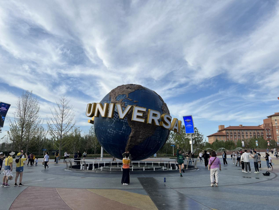 环球城市大道标志性建筑“蓝色大地球”前，人们络绎不绝地拍照留念。中房报记者 李叶/摄