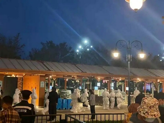 此时是10月31日18时，迪士尼门口出现穿防护服的核酸检测人员/谢诗辰摄