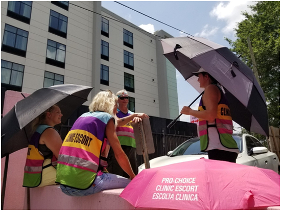 “粉红屋”前的护送孕妇志愿者 图片来源：Pink House Defender官网