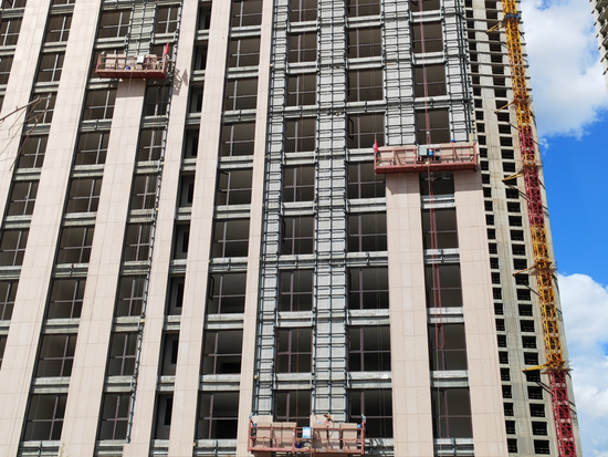 工人们正在对哈尔滨华鸿金色纽约项目进行外墙装饰施工。王迎超/摄