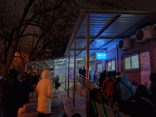 12月9日晚9点，在北京垂杨柳医院，发热门诊的排队人数近百人，部分人排队时长超四小时（张英/摄）