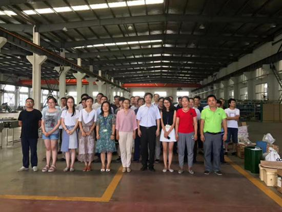  （许荣华第二次被抓释放后与员工在车间合影，首排右四为许荣华）