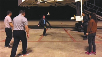 11月28日凌晨，嘎洒机场一处停机坪，几名乘客在踢毽子。