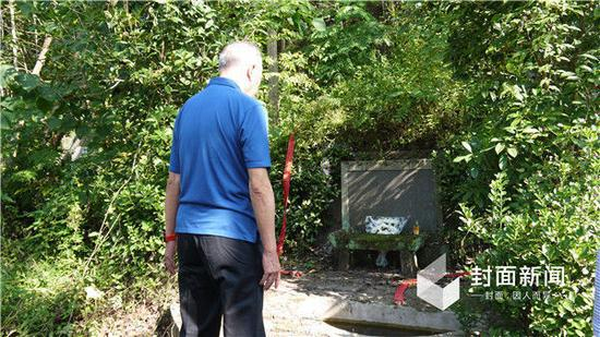 资料图：站在父母墓前，牟其中沉思。