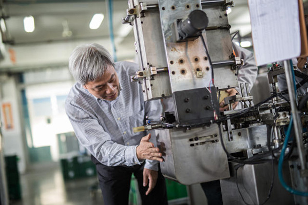 上海真彩文具股份有限公司董事长黄小喜正在调试多工位笔头加工机